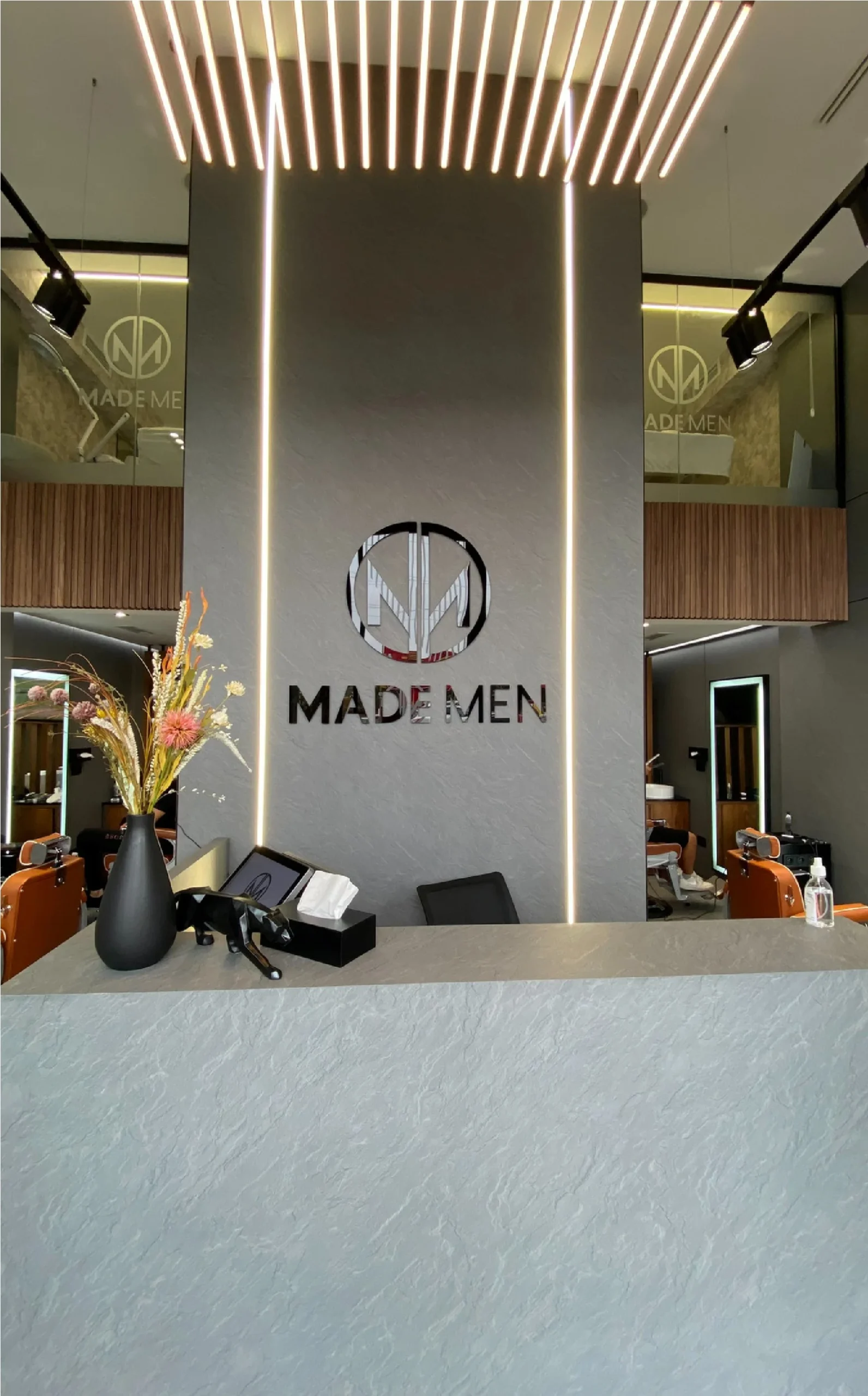 Barber stations with cognac leather chairs and mirror lighting