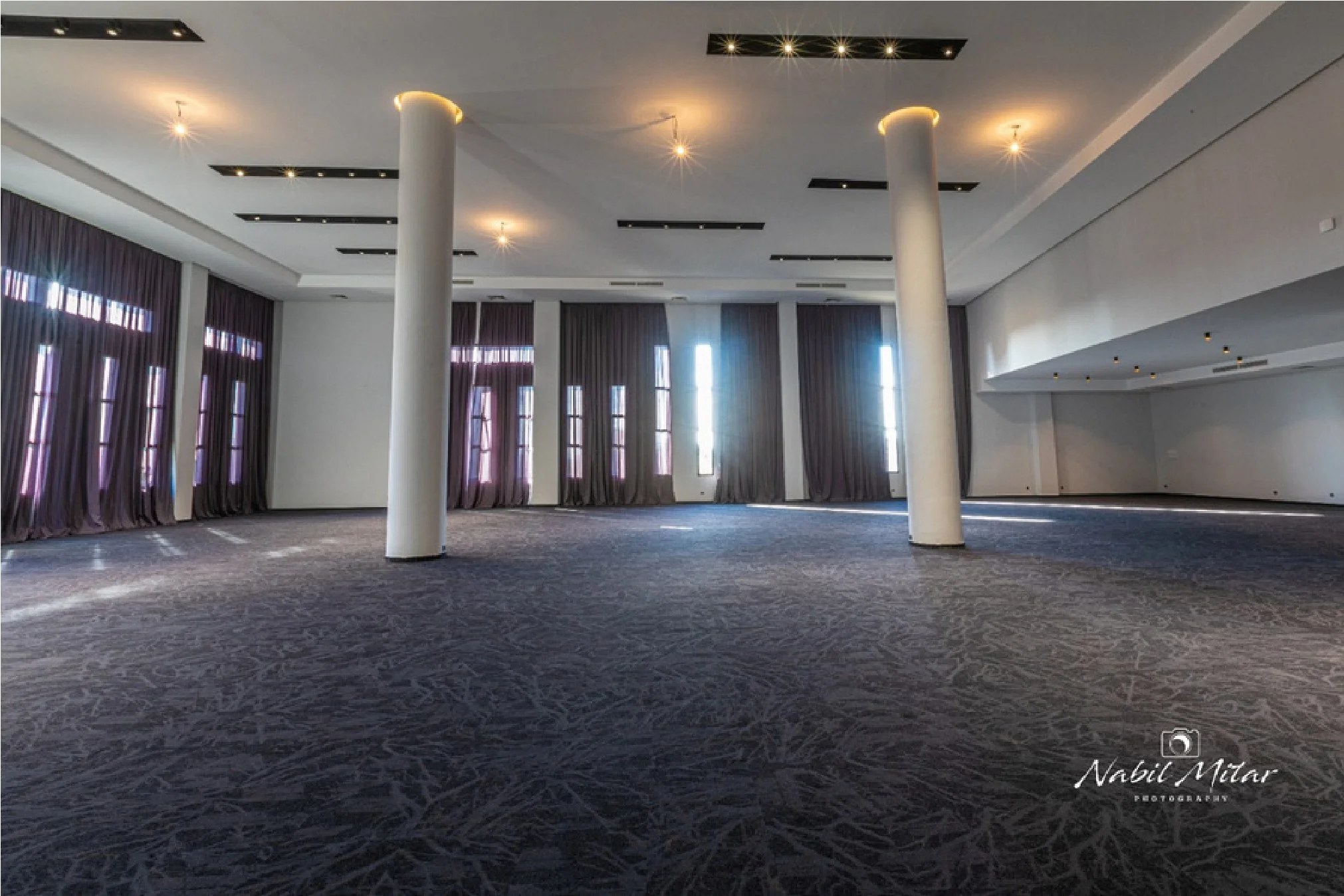 Main lounge with green velvet sofas and marble art panel wall
