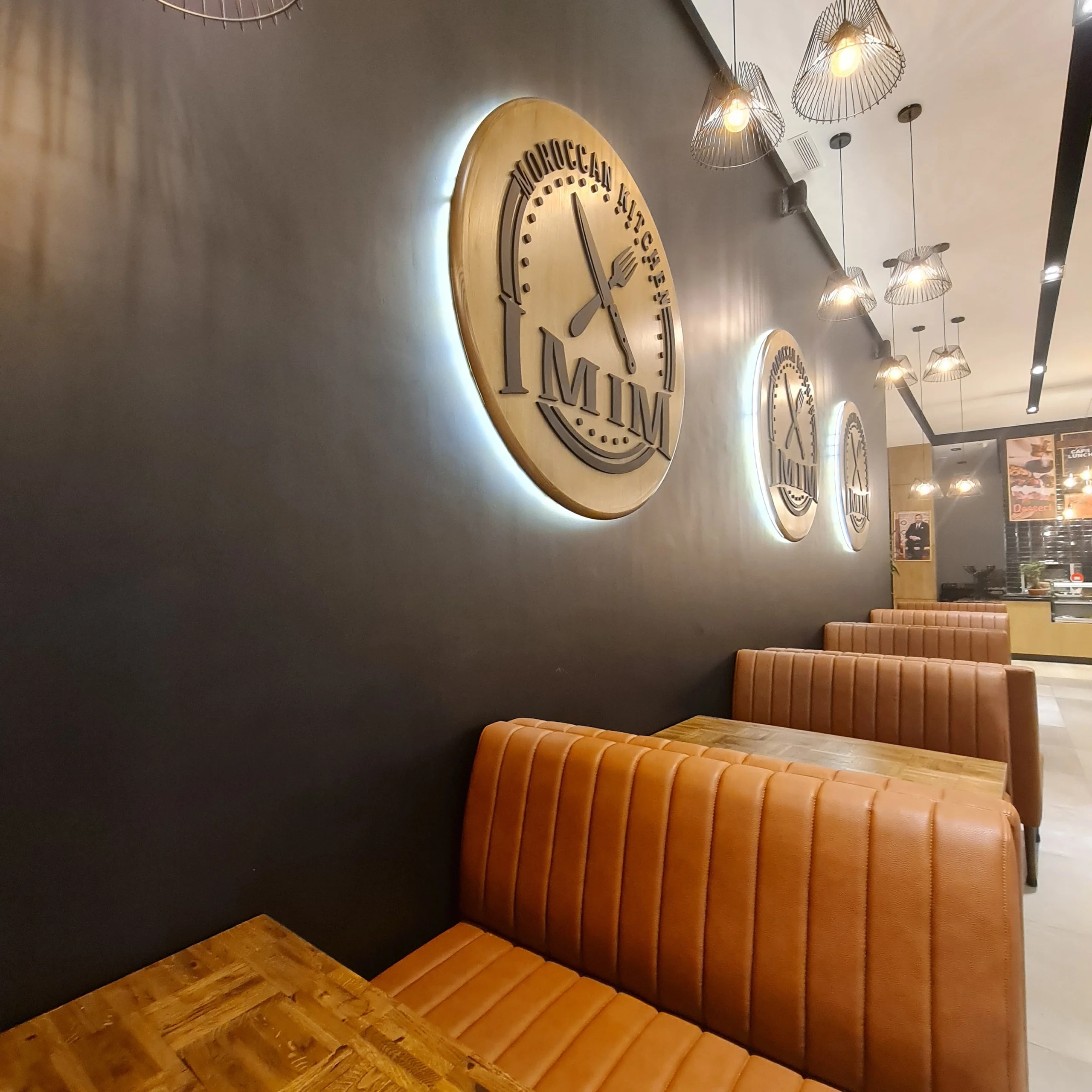 Main dining area with matte black walls and leather banquettes